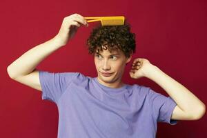 cute red-haired guy in purple t-shirts with a comb isolated background photo