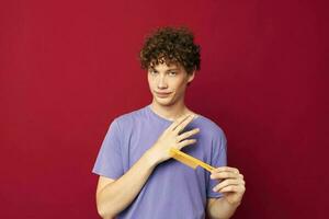portrait of a young curly man in purple t-shirts with a comb Youth style photo