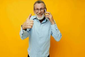 old man gray beard with glasses talking on the phone isolated background photo