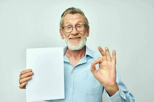 Portrait of happy senior man blank sheet of paper gesture hands smile cropped view photo