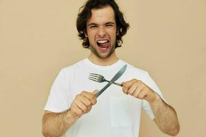 alegre hombre emociones cuchillo y tenedor batería de cocina aislado antecedentes foto