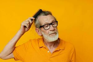 an elderly man in a yellow T-shirt with a comb gray hair photo