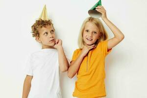 picture of positive boy and girl with caps on his head holiday entertainment light background photo