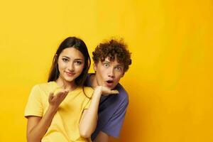 portrait of a man and a woman casual clothes posing emotions antics yellow background unaltered photo