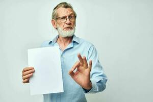 elderly man holding a sheet of paper copy-space posing isolated background photo