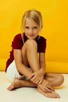 little girl sitting on the floor yellow background emotions photo