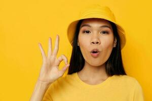 woman in a yellow t-shirt and hat posing emotions isolated background unaltered photo