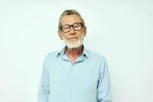 Senior grey-haired man in blue shirts gestures with his hands light background photo