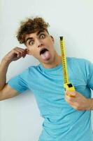 handsome young man blue t-shirt measuring tape posing isolated background photo