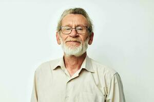 Photo of retired old man with a gray beard in a shirt and glasses light background