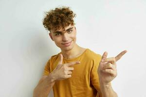 atractivo hombre en amarillo camisetas gesto manos emociones estilo de vida inalterado foto