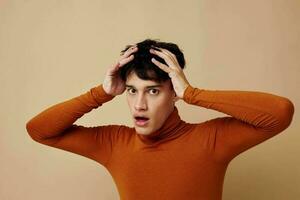 portrait of a young man posing in brown sweater self confidence fashion light background unaltered photo