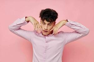 handsome guy gestures with hands emotions hairstyle fashion pink background unaltered photo