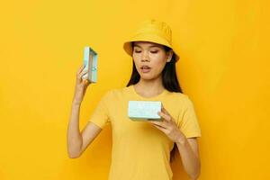 woman in a yellow T-shirt and a hat with a gift studio model unaltered photo