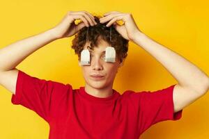 guy with red curly hair posing emotions tea bags yellow background unaltered photo