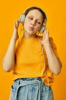 gracioso niña amarillo camiseta auriculares entretenimiento música divertido aislado antecedentes inalterado foto