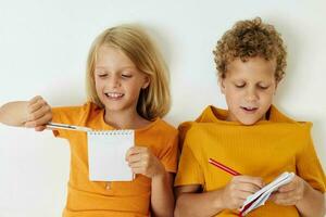 dos alegre niños emociones dibujo juntos bloc y lapices infancia estilo de vida inalterado foto