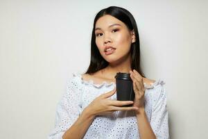 woman with Asian appearance in a white shirt a glass with a drink posing isolated background unaltered photo