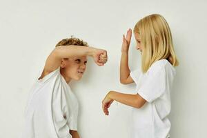 Little boy and girl in white T-shirts are standing next to isolated background photo