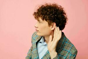 portrait of a young curly man checkered blazer elegant style posing fashion pink background unaltered photo