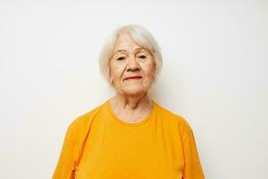 Cheerful elderly woman in casual t-shirt gestures with his hands cropped view photo