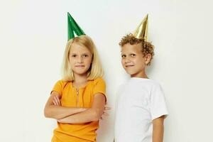 Portrait of cute children posing emotions holiday colorful caps light background photo