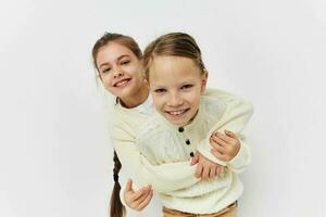dos pequeño muchachas en pie lado por lado divertido infancia foto