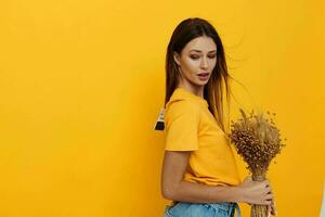 Young woman in yellow T-shirts, dried flowers in hands isolated background photo