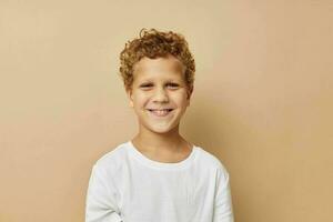 chico con Rizado pelo en un blanco camiseta posando foto