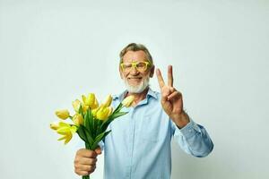 Portrait of happy senior man yellow bouquet of flowers posing isolated background photo