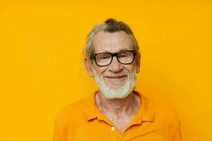 an elderly man with glasses in a yellow t-shirt with glasses close-up photo