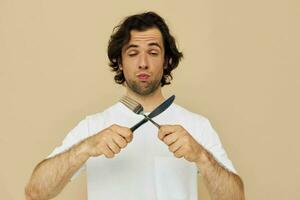 alegre hombre emociones cuchillo y tenedor batería de cocina aislado antecedentes foto