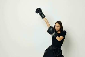 young beautiful woman in boxing gloves punch in black pants and a T-shirt Lifestyle unaltered photo