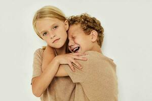 Little boy and girl gesticulate with their hands together light background photo