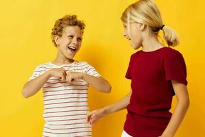 Small children standing side by side posing childhood emotions on colored background photo