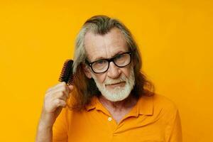 an elderly man in a yellow T-shirt with a comb gray hair photo