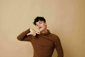 handsome guy brown turtleneck posing fashion light background unaltered photo