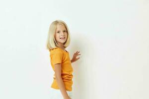 little girl with blond hair in a yellow t-shirt isolated background photo