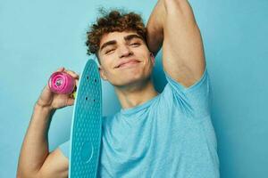 handsome young man skateboard in hand in blue t-shirts unaltered photo