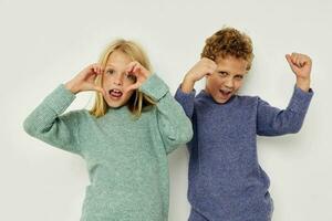 Boy and girl in multi-colored sweaters posing for fun Lifestyle unaltered photo