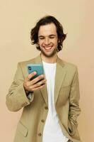 Cheerful man with a phone in hand beige suit elegant style Lifestyle unaltered photo