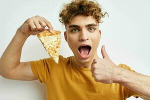 handsome guy eating pizza posing close-up light background photo