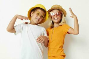 chico y niña vistiendo sombreros Moda lentes posando amistad divertido foto