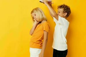 a boy with a comb combing a girl's hair yellow background photo