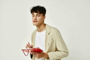 portrait of a young man posing with a notepad in a suit isolated background unaltered photo