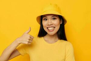 woman in a yellow t-shirt and hat posing emotions isolated background unaltered photo