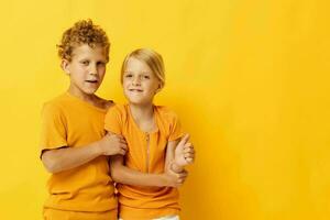 two joyful children cuddling fashion childhood entertainment on colored background unaltered photo