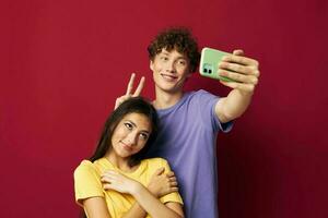 young man and girl in colorful T-shirts with a phone Youth style photo