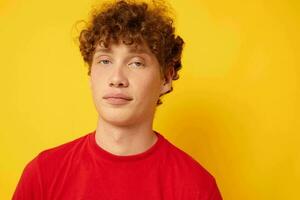 cute guy with curly hair in a red t-shirt close-up photo