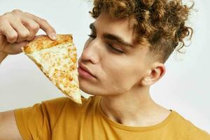 rizado chico comiendo Pizza posando de cerca aislado antecedentes foto